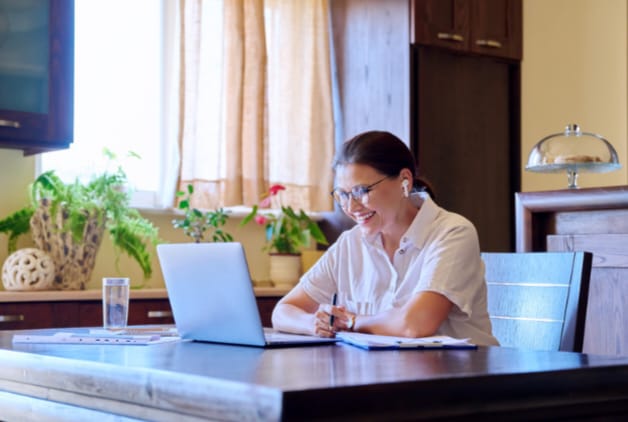 Mulher olhando para o notebook durante uma sessão de terapia online para colaboradores.