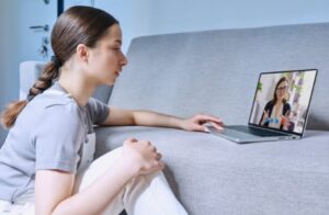 Mulher em chamada de vídeo fazendo uma consulta de tratamento psicológico para depressão.