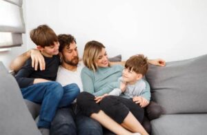 A imagem mostra pai, mãe e dois meninos, representando uma família com crianças neuroatípicas.