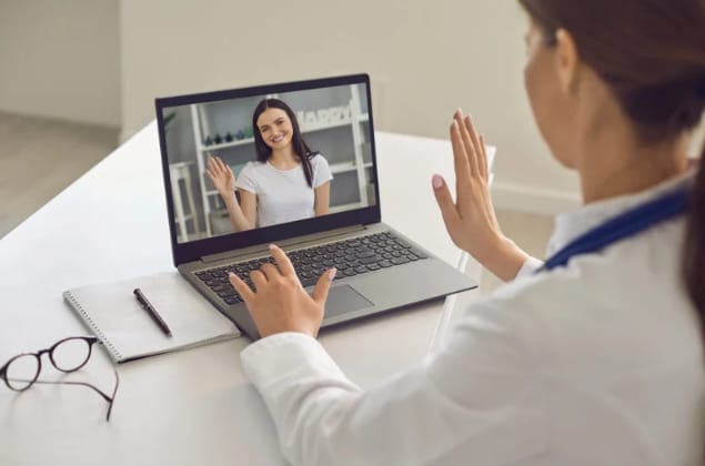 Mulheres conectadas em um notebook durante sessão de terapia holística online.