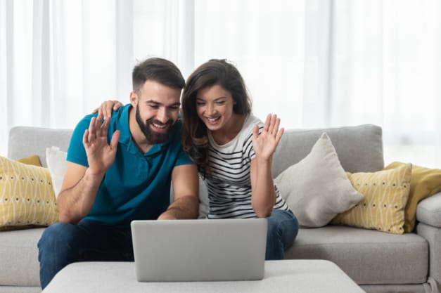 Casal usando o laptop para sessão de terapia online em Maceió.