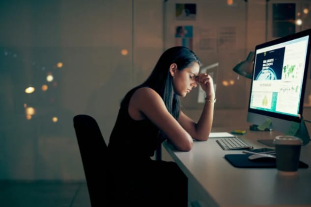 Mulher cansada em frente ao computador esperando pela sessão de terapia online para burnout