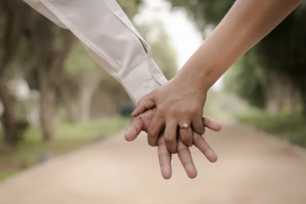 Casal de mãos dadas após terapia online para casais.