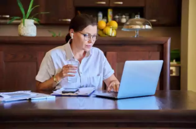 Mulher usando o notebook para fazer sessão de terapia online no Rio de Janeiro.